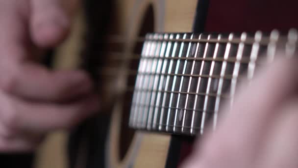 Man starts playing guitar, dynamic change of focus, close up — Stock Video