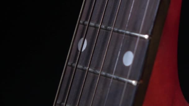 Play strings of acoustic guitar, side view, on black, close up, slow motion — Stock Video