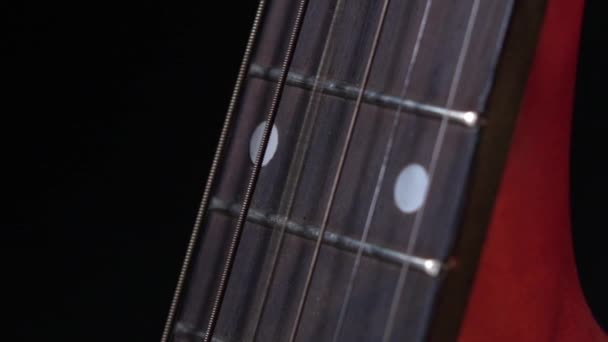 Hrát struny akustická kytara, boční pohled, třetí řetězec na černém, zblízka, zpomaleně — Stock video