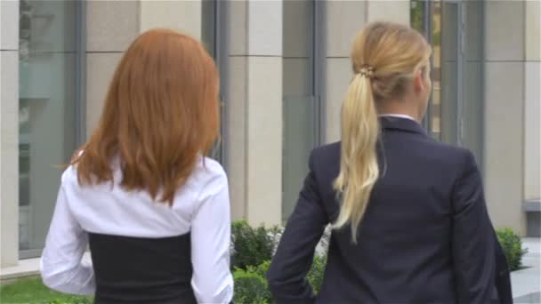 Two businesswoman walking on the street near office building, slow motion — ストック動画