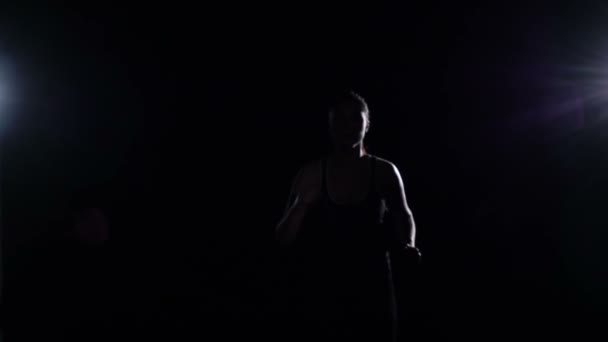 Mulher esportiva correndo para fora da escuridão no ginásio, câmera lenta — Vídeo de Stock