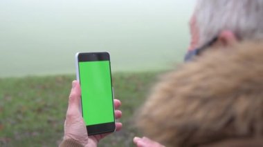 Video araması için akıllı telefon kullanan kıdemli adamın yavaş hareketi