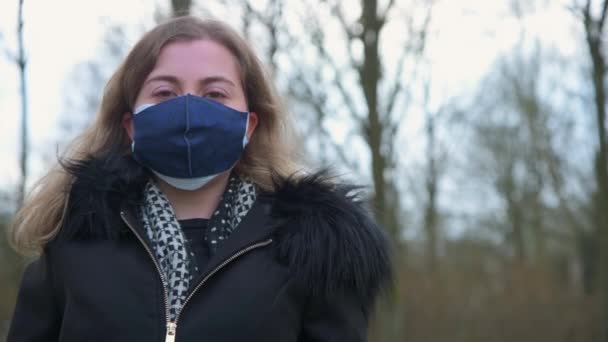 Νεαρή Γυναίκα Φοράει Δύο Μάσκες Στην Περιοχή Του Δάσους — Αρχείο Βίντεο