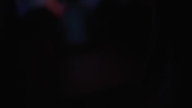 Dizüstü bilgisayar kullanan bir kadın hacker 'ın omuz üstünden çekilen bir el kamerası.