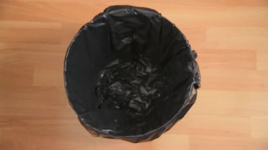 Genel bir çöp kutusuna konan plastik şişelerin havadan hareketli görüntüsü.