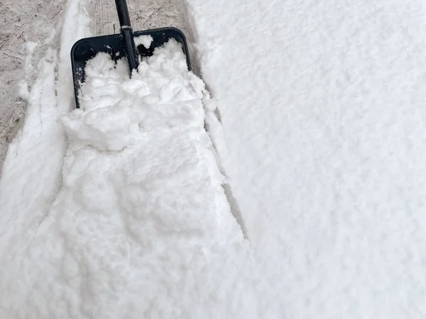 cleaning snow with a shovel during a winter day