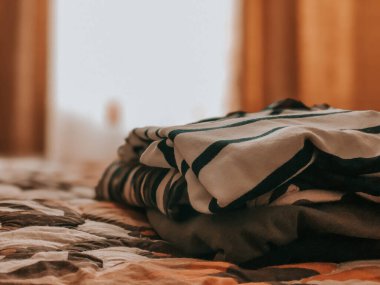 Giysiler yatağın üstüne yığılmış..