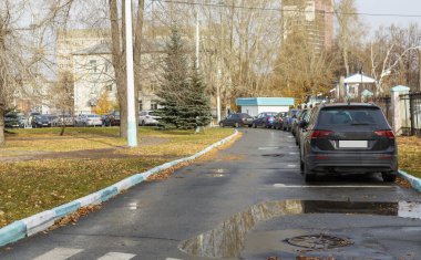 Çitin yakınındaki otoparkta arabalar ve geçitler var. bulanık odak