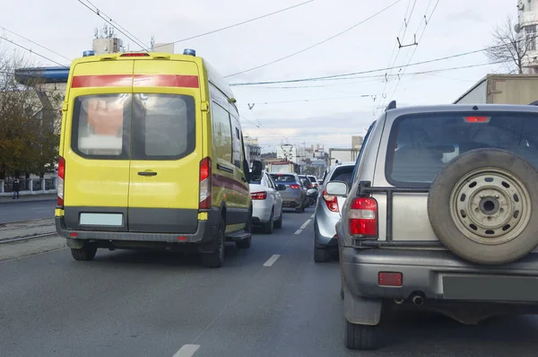 An intensive care ambulance moves in a stream of cars along a city street to a patient during quarantine for the covid-19 coronavirus pandemic. blurred focus