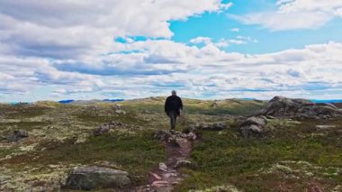 Engebeli Dağ Tundra Patikası 'nda Yürüyen Yürüyüşçü Dramatik Bulutlar Altında Sinema Dolly Out / Track Back Çekimi