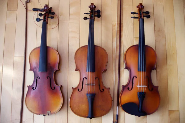 Três Instrumentos Música Violinos Marrons Fundo Chão Madeira — Fotografia de Stock