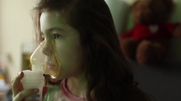 Flickan inhalerar läkemedlet via inhalatorn. Bronkit behandling. Andningshjälp — Stockvideo