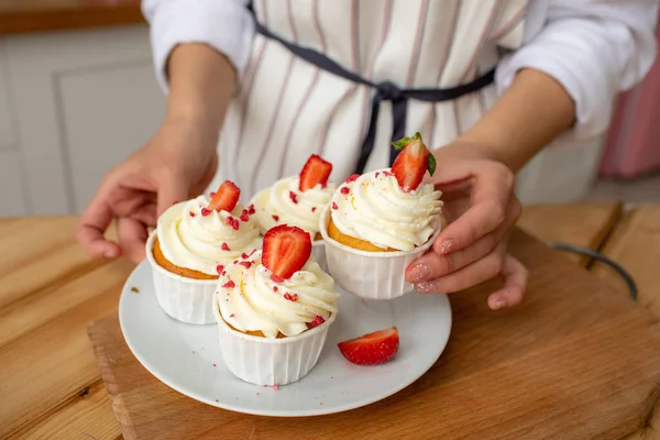 Cupcakes with butter cream, decorated with strawberries and raspberries