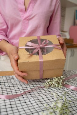 Pasta paketi. Kız bankayı paketleme kutusuna bağlıyor..