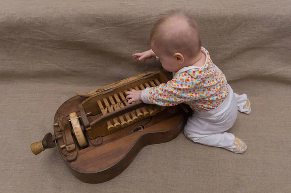 Ett Litet Barn Kröp Täcket Tangentbordet Ett Uråldrigt Musikinstrument Trä — Stockfoto