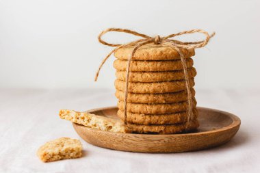 Yulaf ezmeli kurabiyeler ahşap bir tabakta iplikle bağlanır. Kahvaltı ya da atıştırmalık sağlıklı yiyecekler. Yan görüş. Boşluğu kopyala.