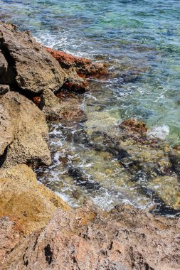 Taş kıyıya yakın çekim. Mallorca adasında temiz deniz suyu.