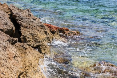Taş kıyıya yakın çekim. Mallorca adasında temiz deniz suyu.