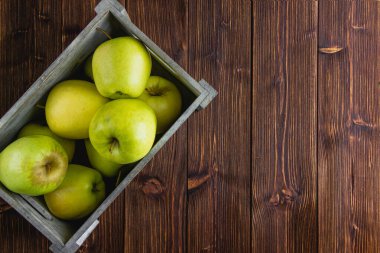 Ahşap bir arka planda sarı elmalar. Kopya alanı olan taze meyvelerin üst görünümü.