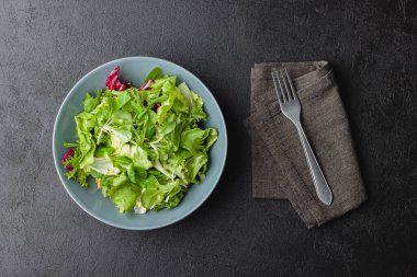Siyah masada yeşil salata yaprakları. Taze ve sağlıklı yiyecekler. Üst görünüm.