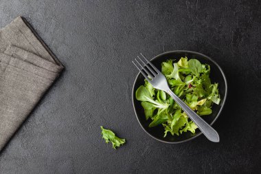 Siyah masada yeşil salata yaprakları. Taze ve sağlıklı yiyecekler. Üst görünüm.
