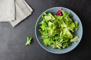 Siyah masada yeşil salata yaprakları. Taze ve sağlıklı yiyecekler. Üst görünüm.