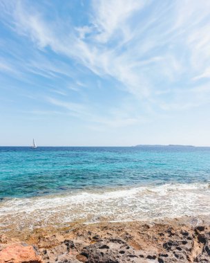 Mallorca adasında vahşi bir sahil manzarası. Mavi güneşli gökyüzü ve beyaz bulutlar.