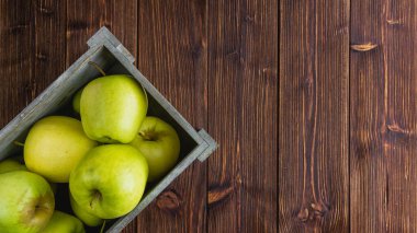Ahşap bir arka planda sarı elmalar. Kopya alanı olan taze meyvelerin üst görünümü.