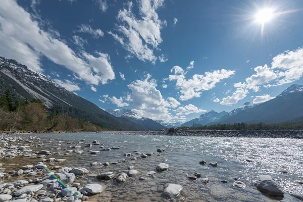 Banco de pedra em fluxo lech rio em tirol lechtal aith céu azul e sol — Fotografia de Stock