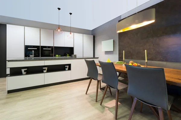 Moderne elegante witte platte keuken met eiland en eettafel — Stockfoto