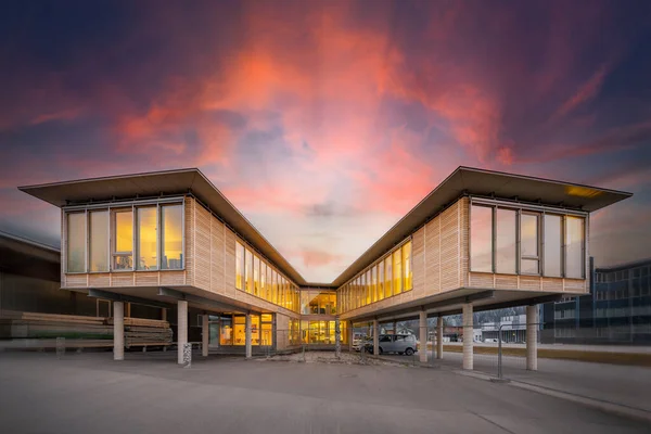 Nowoczesny Zrównoważony Budynek Biurowy Dwoma Drewnianymi Skrzydłami Betonowych Filarach Zachodzie — Zdjęcie stockowe