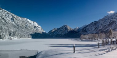Taze kar ve donmuş göl. Güneşli bir kış gününde mavi gökyüzü.