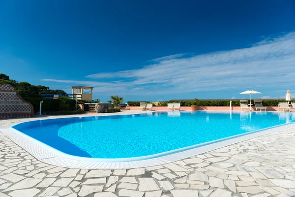 Piscina con borde de baldosas y agua turquesa en el cielo azul — Foto de Stock