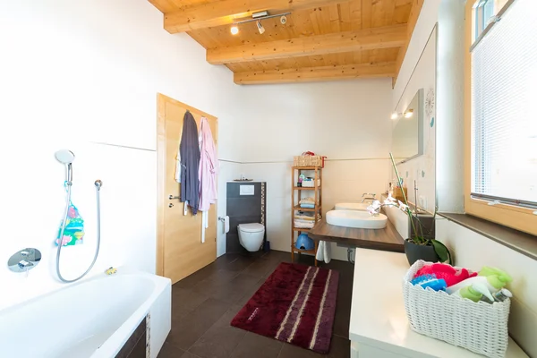 Cuarto de baño con bañera lavabo inodoro en casa de madera caliente —  Fotos de Stock