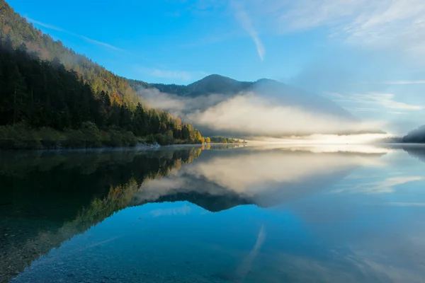 Утренняя пыль на идиллическом озере Планзе осенью с зеркальными горами — стоковое фото