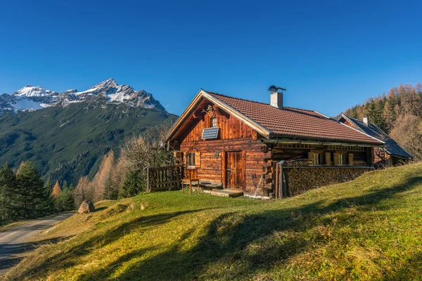 Cabaña de madera vieja cabaña en los alpes de montaña en el paisaje de caída rural — Foto de Stock