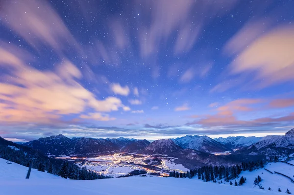 Mountain view over illuminated valley in winter at night — Stock Photo, Image