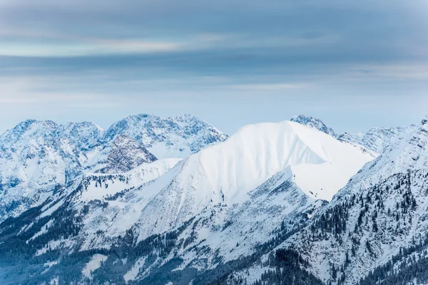 One smooth snowy mountain between rough rocks in austria — Stock Photo, Image