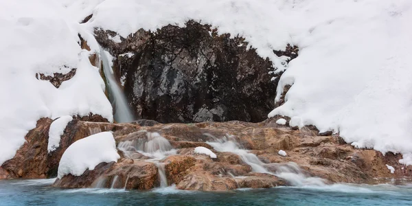Eiskalter Wasserfall zwischen Felsen im Winterschnee — Stockfoto