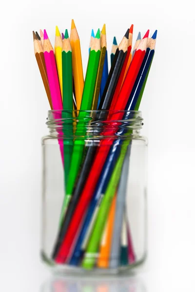 Verre plein de crayons de couleur en bois aiguisés debout sur fond blanc — Photo