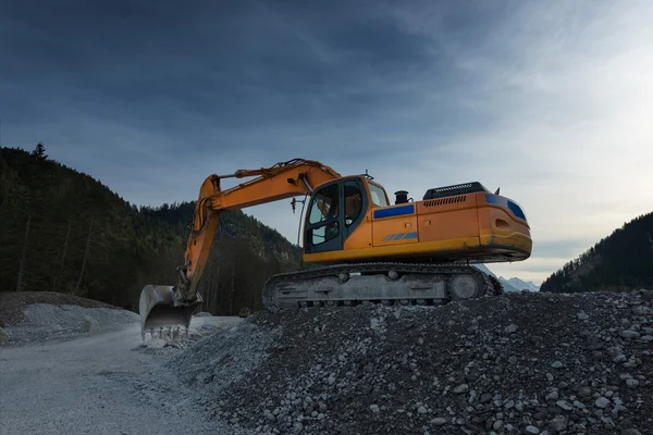 Sideview enorm orange skyffla grävmaskin grävning i grus — Stockfoto