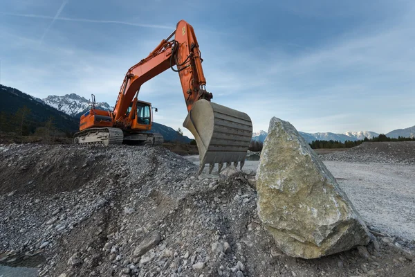 Escavadora enorme pá em pé na colina de cascalho com pedra de rocha — Fotografia de Stock