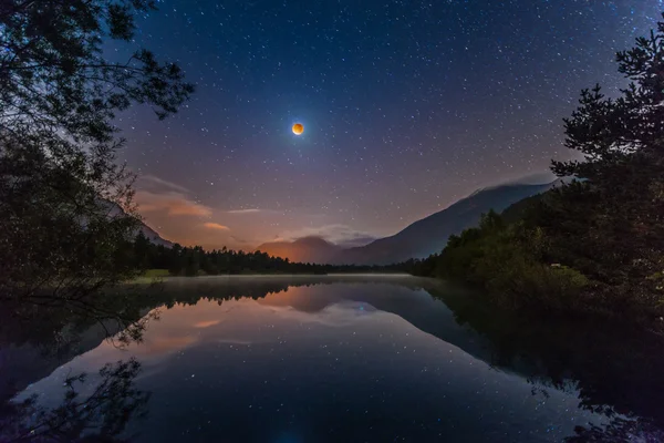 Blood moon with stars  at alpine lake in tyrol — Stock Photo, Image