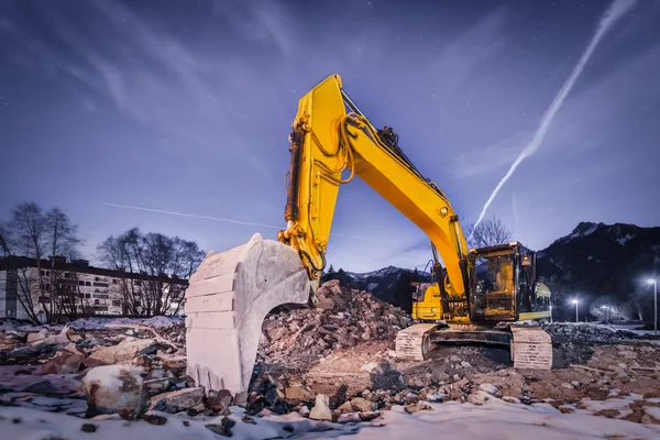 Excavadora enorme pala naranja en el sitio de demolición por la noche — Foto de Stock