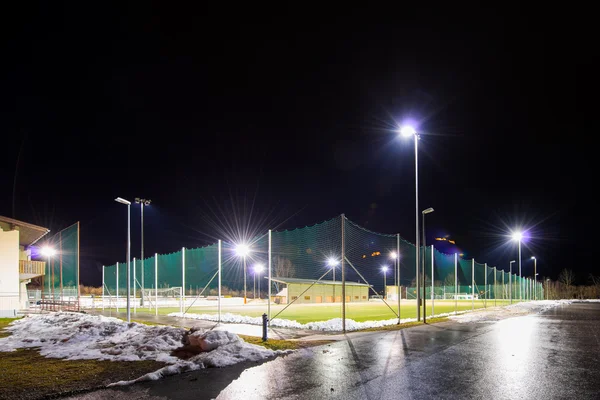 Campo de futebol treinamento com luz de inundação à noite no inverno — Fotografia de Stock