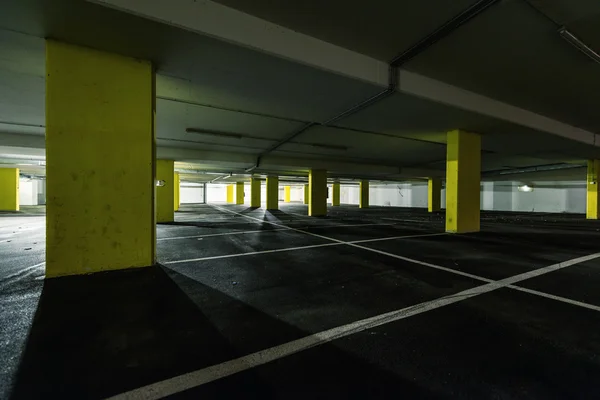 Widok perspektywy poprzez żółty kolumn w parking podziemny — Zdjęcie stockowe
