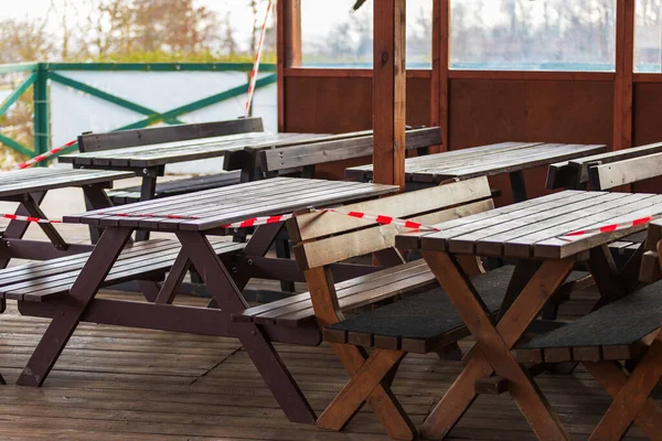 The restaurant garden is closed. Wooden tables and benches at the restaurant.