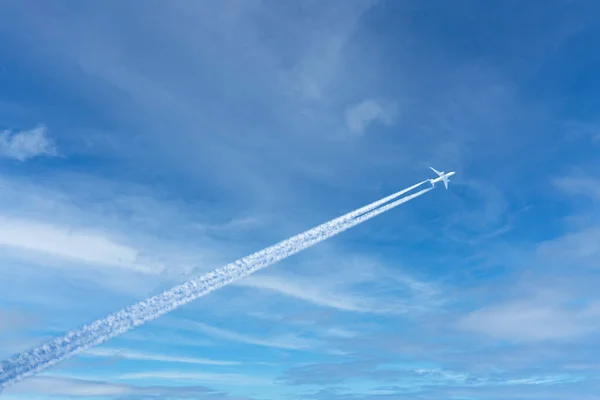 大きな旅客機が空を飛ぶ 青い空に白い雲と飛行機の後ろの歩道があります — ストック写真
