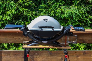 Ahşap bir masanın üzerinde beyaz kapaklı bir ızgara duruyor..