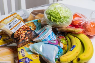 Brno, Çek Cumhuriyeti, Şubat 2021 - Mağazadan alınanlar masaya kondu. Masanın üzerinde meyve, sebze, şeker, tereyağı var..